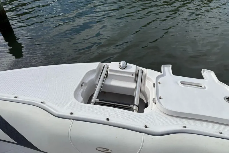 Slide: The Image of 2017 Regal 26 OBX boat with open hatch and ladder on calm water. - 26