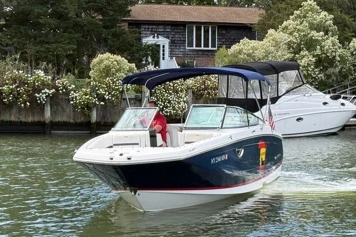 Slide: The Image of 2017 Regal 26 OBX boat cruising on a scenic waterway near a house. - 7