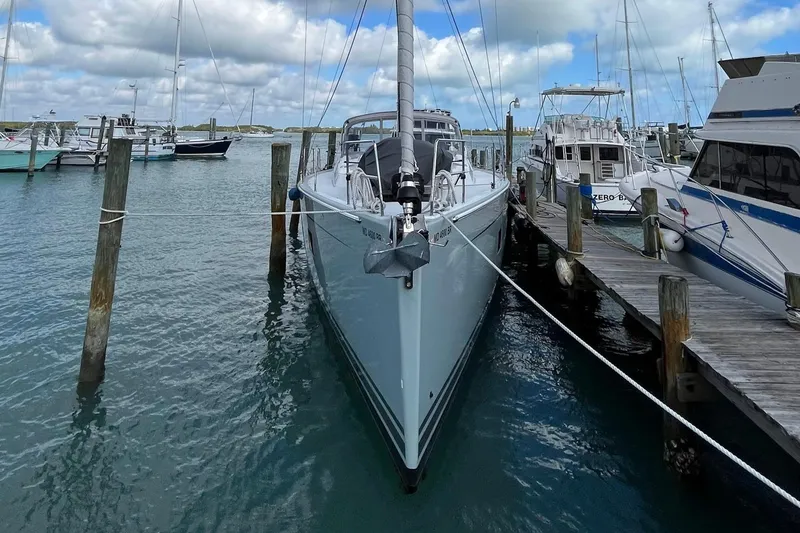 Slide: The Image of 2021 Hanse 508 yacht docked at marina, surrounded by other boats under a cloudy sky. - 1