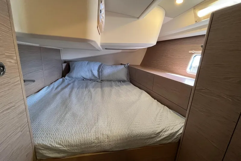 Slide: The Image of Cozy bedroom interior of 2021 Hanse 508 yacht with modern wood finish and soft lighting. - 16