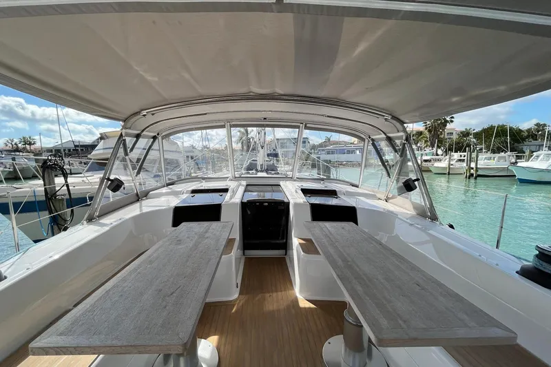 Slide: The Image of Spacious cockpit of 2021 Hanse 508 yacht with wooden tables and marina view. - 8