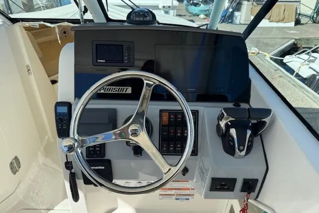Slide: The Image of 2021 Pursuit DC 266 Dual Console boat helm with steering wheel and control panel. - 10