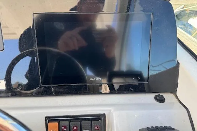 Slide: The Image of 2021 Pursuit DC 266 Dual Console dashboard with Garmin display and control panel. - 12