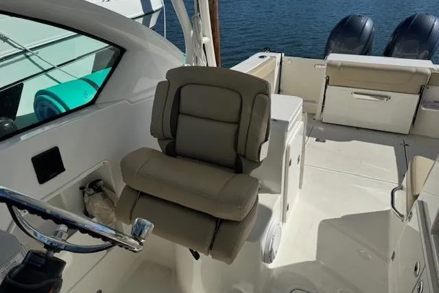 Slide: The Image of 2021 Pursuit DC 266 Dual Console boat interior with helm seat and twin engines. - 13