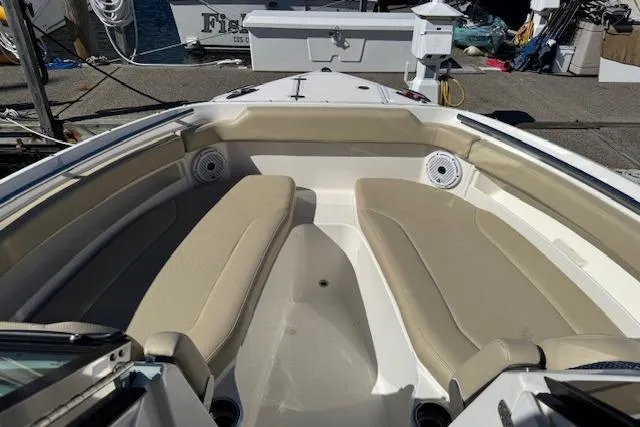 Slide: The Image of 2021 Pursuit DC 266 Dual Console boat interior with beige seating and speakers. - 15