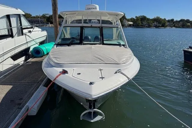 Slide: The Image of 2021 Pursuit DC 266 Dual Console boat docked on calm water. - 2