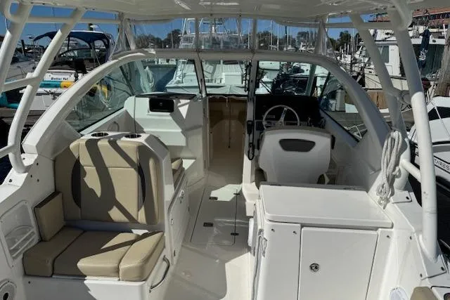 Slide: The Image of 2021 Pursuit DC 266 Dual Console boat interior with seating and helm, docked at marina. - 6