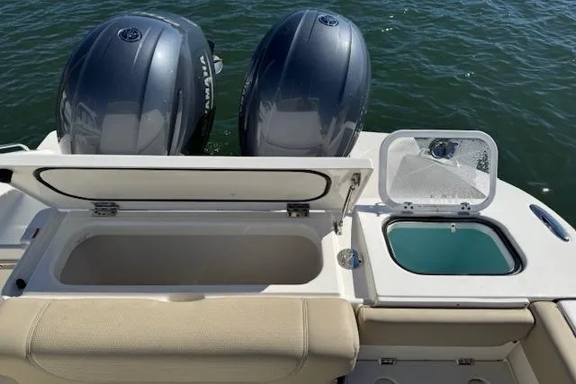 Slide: The Image of 2021 Pursuit DC 266 Dual Console boat with open storage and twin engines on water. - 9