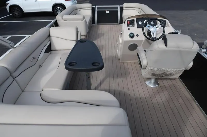 Slide: The Image of 2020 Bennington 21 SL pontoon boat interior with beige seating and steering console. - 14