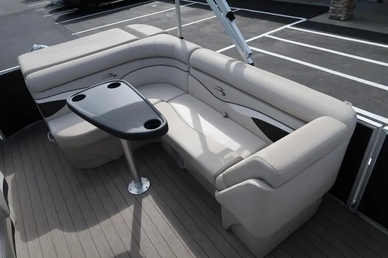 Slide: The Image of 2020 Bennington 21 SL boat interior with beige seating and a small table. - 17