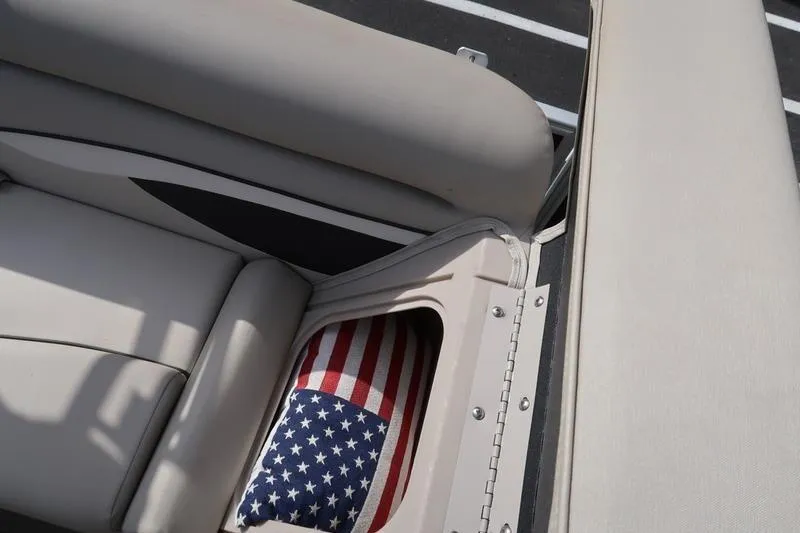 Slide: The Image of 2020 Bennington 21 SL boat interior with American flag cushion in storage compartment. - 19