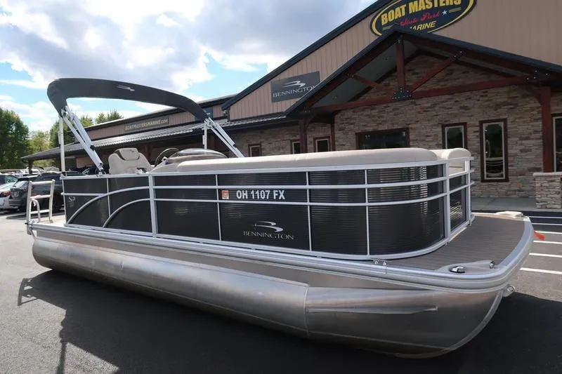Slide: The Image of 2020 Bennington 21 SL pontoon boat parked outside dealership. - 2