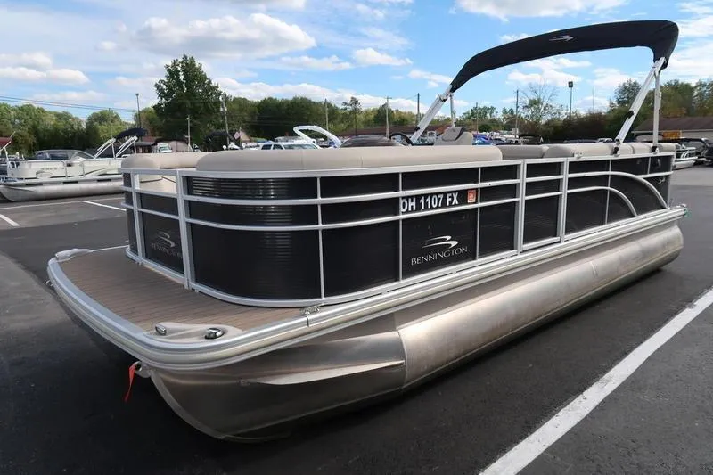 Slide: The Image of 2020 Bennington 21 SL pontoon boat parked on asphalt with blue sky background. - 9