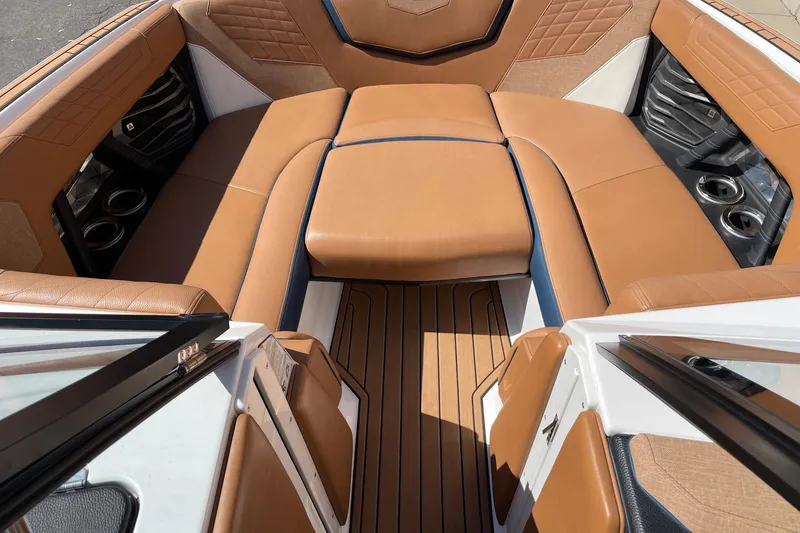 Slide: The Image of 2021 Nautique Super Air Nautique G23 interior with tan leather seating and cup holders. - 11