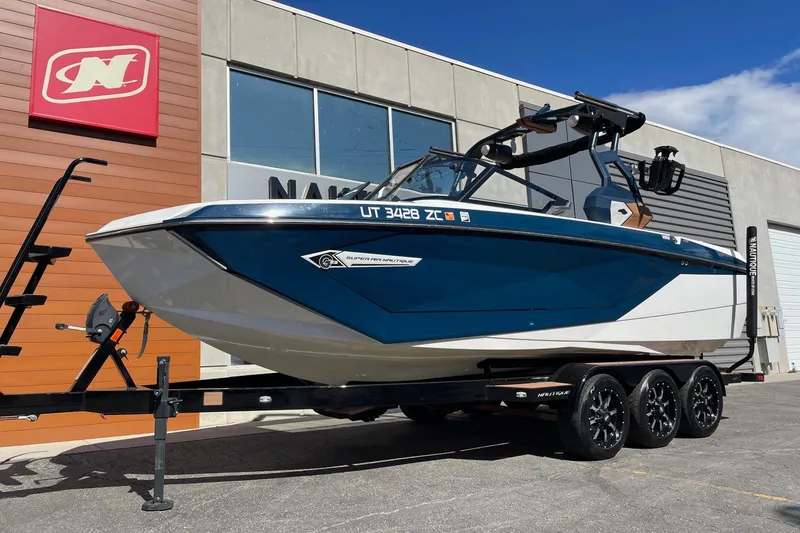 Slide: The Image of 2021 Nautique Super Air Nautique G23 boat on trailer outside dealership. - 2