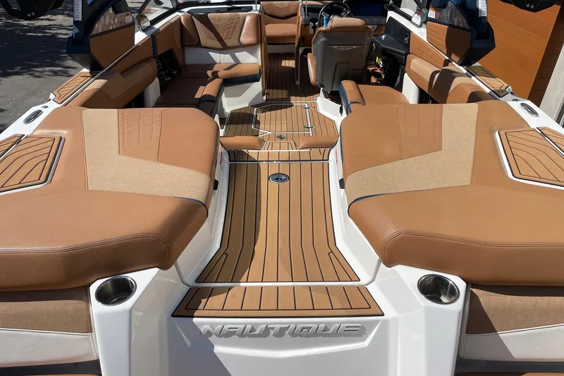 Slide: The Image of 2021 Nautique Super Air Nautique G23 interior with tan upholstery and teak-style flooring. - 4