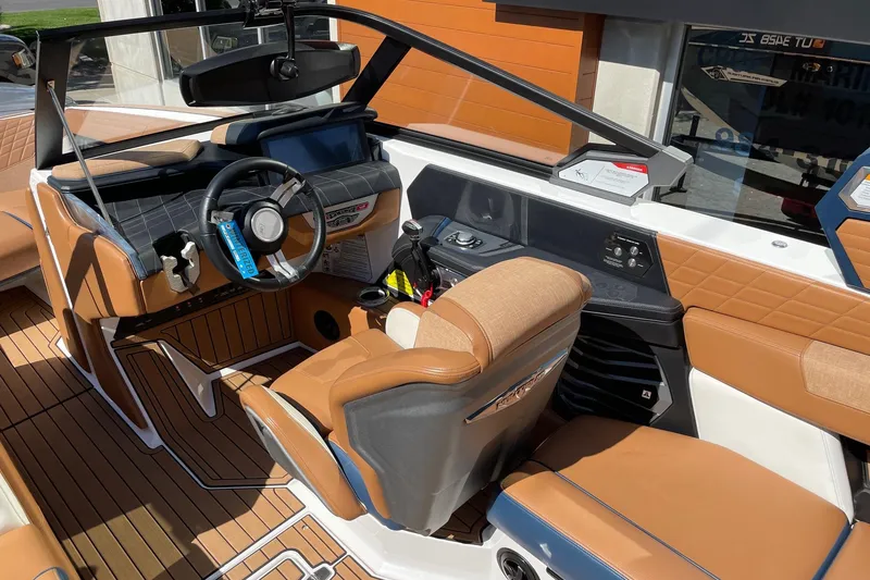 Slide: The Image of 2021 Nautique Super Air Nautique G23 boat interior with luxurious seating and modern dashboard. - 6