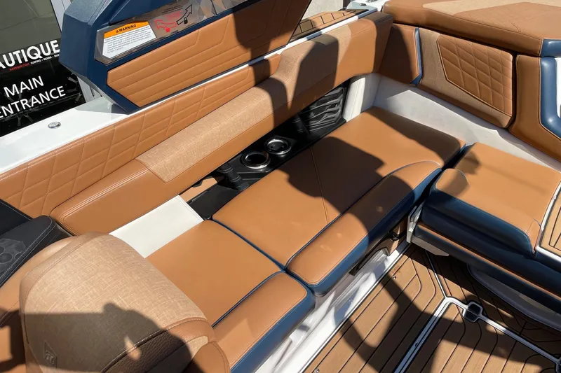 Slide: The Image of 2021 Nautique Super Air Nautique G23 interior with tan leather seating and cup holders. - 7