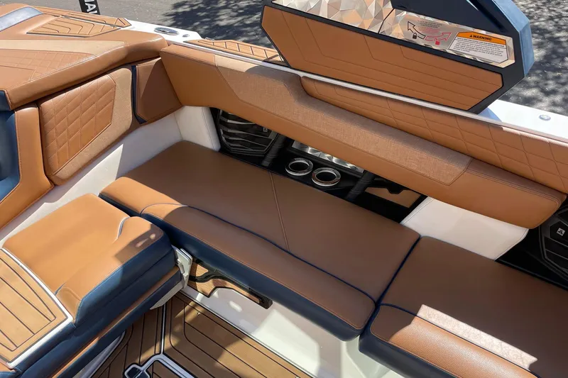 Slide: The Image of 2021 Nautique Super Air Nautique G23 interior with tan leather seating and cup holders. - 9