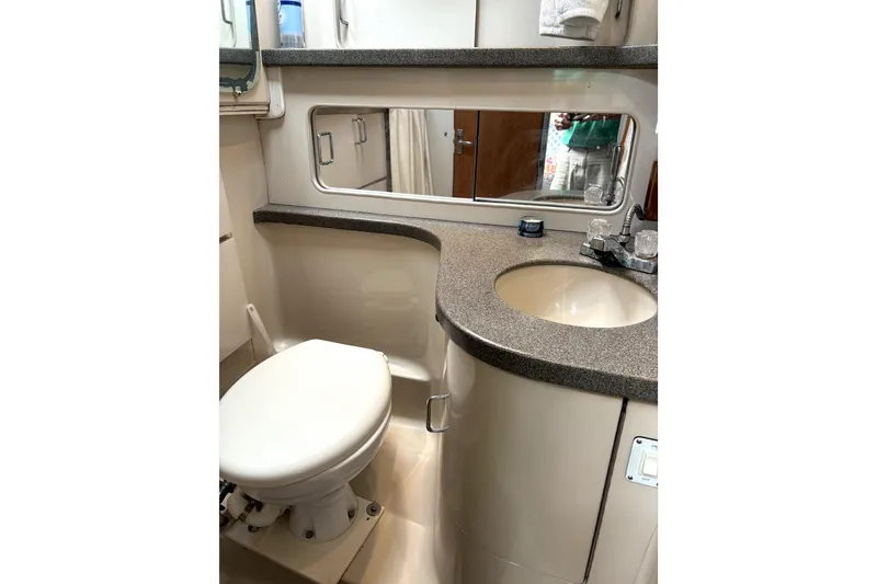 Slide: The Image of 1995 Luhrs Open Express bathroom with toilet, sink, and mirror. - 16