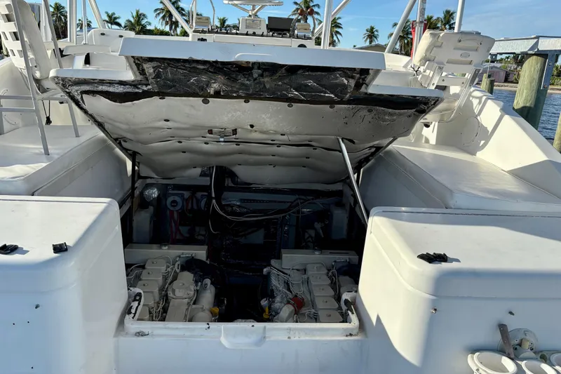 Slide: The Image of 1995 Luhrs Open Express boat engine compartment with open hatch, docked near palm trees. - 19