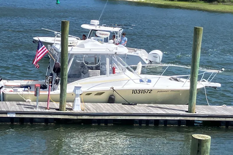 Slide: The Image of 1995 Luhrs Open Express boat docked with American flag, calm water background. - 2