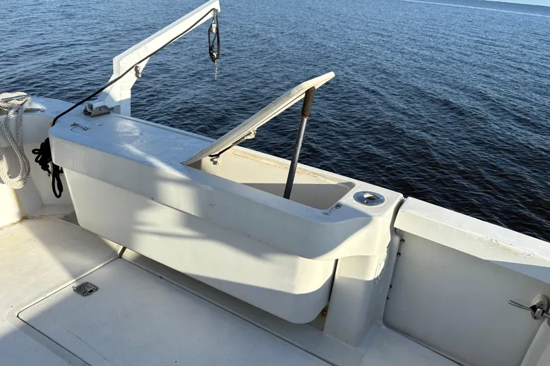 Slide: The Image of 1995 Luhrs Open Express boat deck with open storage compartment, overlooking calm water. - 26