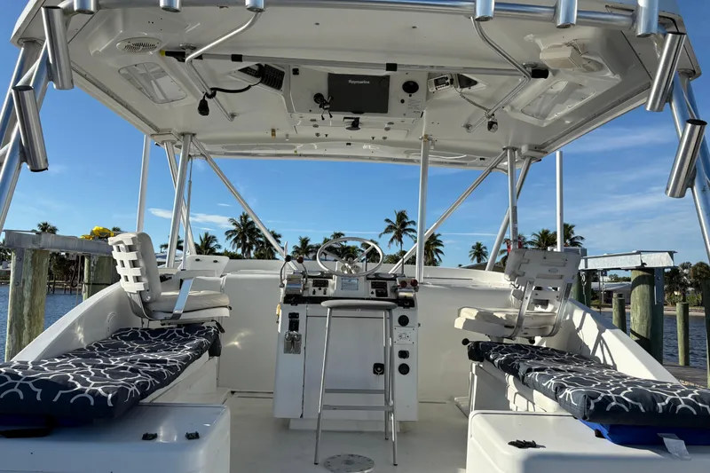 Slide: The Image of 1995 Luhrs Open Express boat interior with helm, seating, and palm trees in the background. - 30