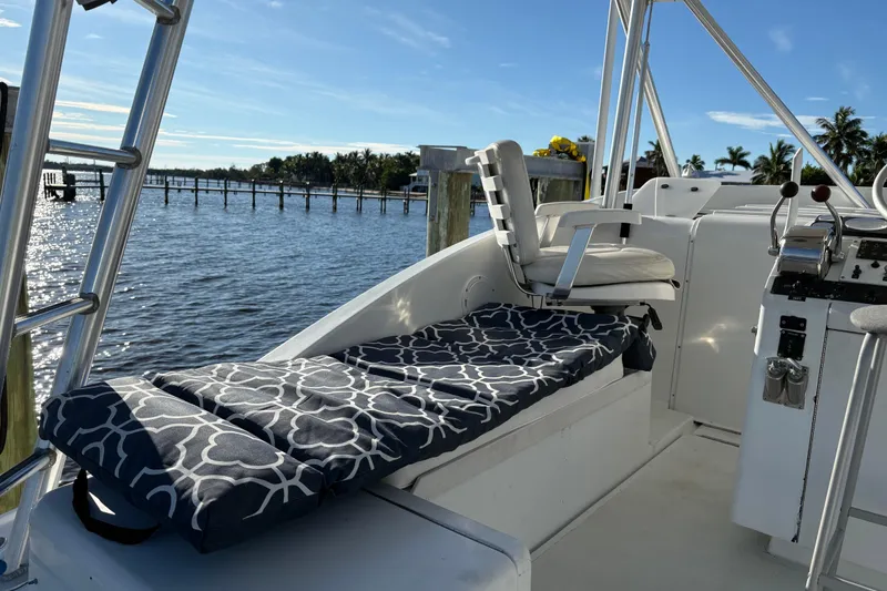Slide: The Image of 1995 Luhrs Open Express boat interior with cushioned seating, steering controls, and scenic water view. - 34
