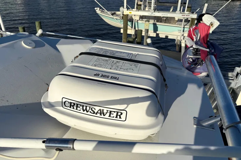 Slide: The Image of 1995 Luhrs Open Express boat with Crewsaver life raft on deck, docked by the water. - 4