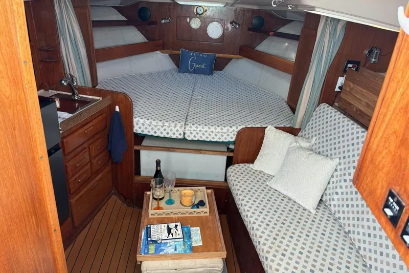 Slide: The Image of 1995 Luhrs Open Express cabin interior with cozy seating, bed, and kitchenette. - 13
