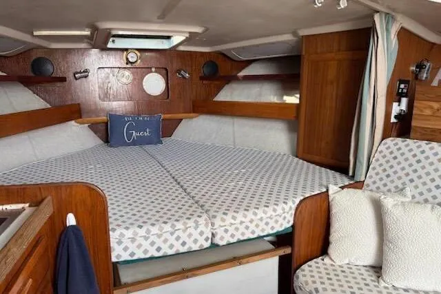 Slide: The Image of 1995 Luhrs Open Express cabin interior with cozy bedding and wooden accents. - 14