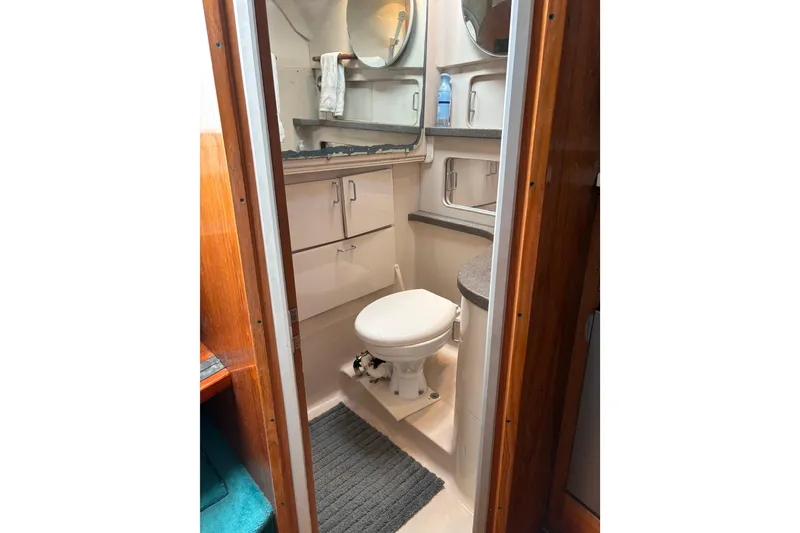 Slide: The Image of Bathroom interior of 1995 Luhrs Open Express boat, featuring toilet and storage cabinets. - 18