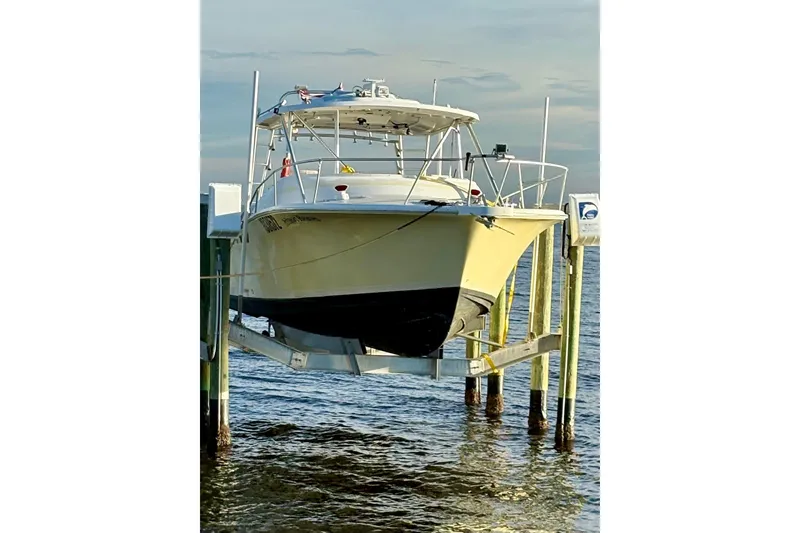 Slide: The Image of 1995 Luhrs Open Express boat on lift over water, front view. - 28