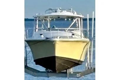 Slide: The Image of 1995 Luhrs Open Express boat on lift, front view, in calm waters. - 44