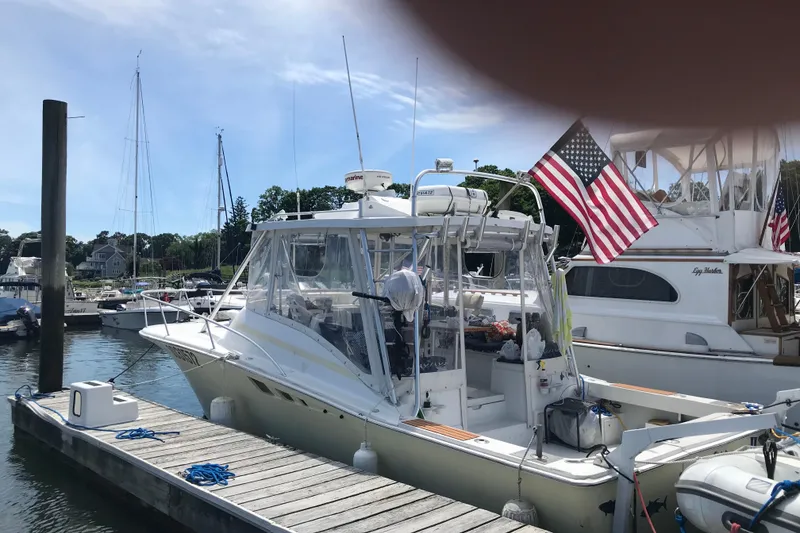 Slide: The Image of 1995 Luhrs Open Express boat docked with American flag, clear skies, and marina background. - 7