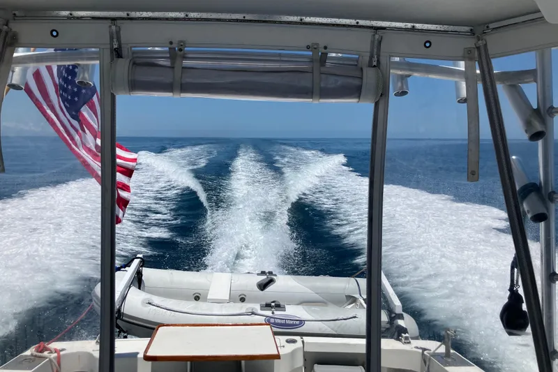 Slide: The Image of 1995 Luhrs Open Express boat cruising with American flag, ocean view from cockpit. - 8