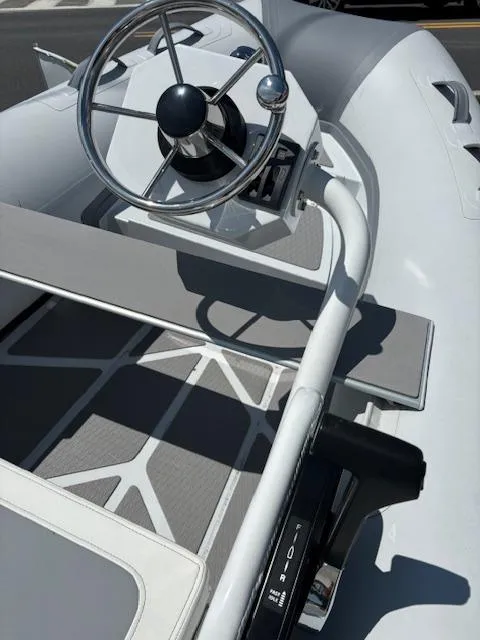 Slide: The Image of 2024 Inmar 325R-AL inflatable boat with steering wheel and seating. - 2