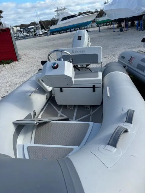 Slide: The Image of 2024 Inmar 325R-AL inflatable boat at a marina, featuring a sleek design and modern controls. - 6