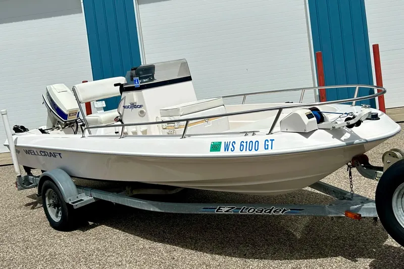 The Image of 1997 Wellcraft 160 Fisherman boat on EZ Loader trailer, parked outdoors. - 0