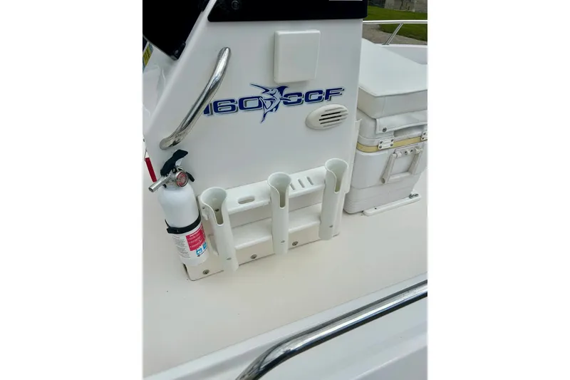 Slide: The Image of 1997 Wellcraft 160 Fisherman with Evinrude outboard motor, parked near blue building. - 16