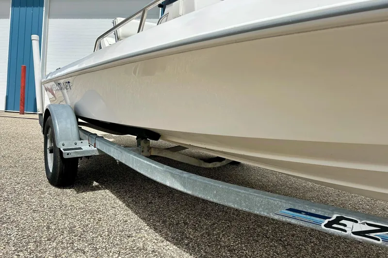 Slide: The Image of 1997 Wellcraft 160 Fisherman boat with white deck and seating, docked outdoors. - 2