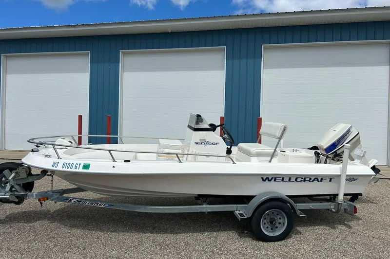 Slide: The Image of 1997 Wellcraft 160 Fisherman boat on trailer, parked by blue building. - 21