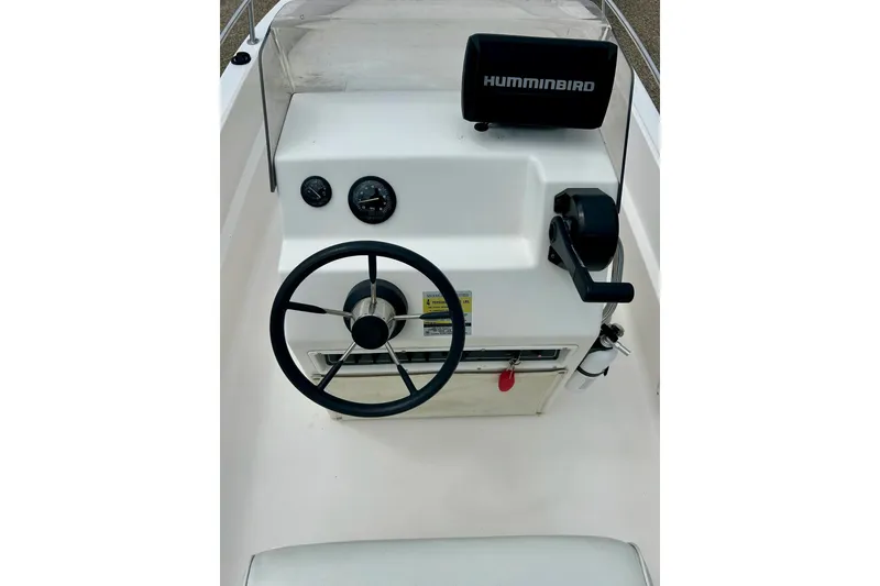 Slide: The Image of 1997 Wellcraft 160 Fisherman boat on trailer, parked outside blue building. - 22