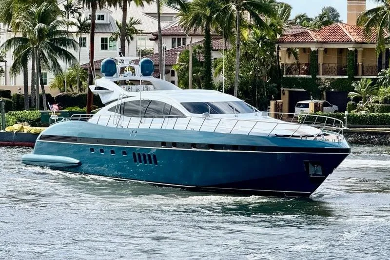 The Image of Luxury 2005 Mangusta 92 yacht cruising near waterfront homes and palm trees. - 0