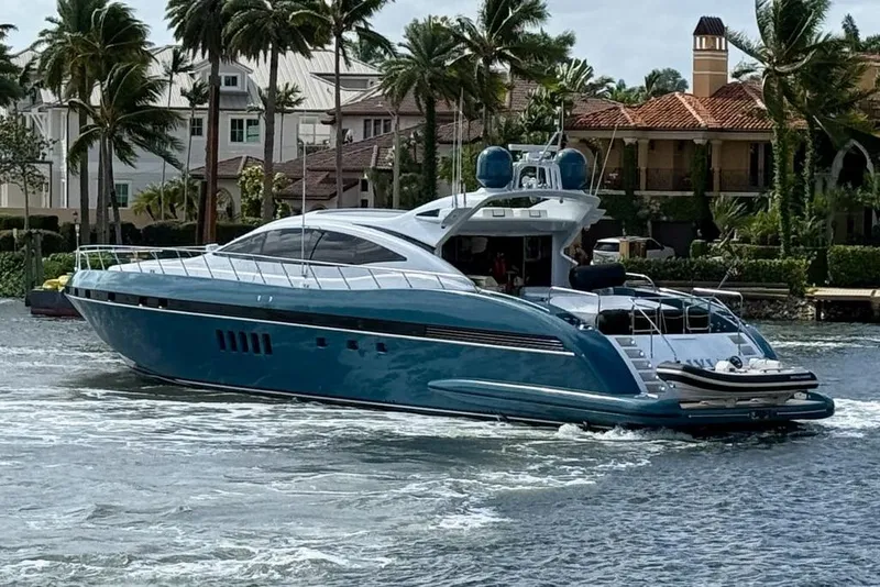Slide: The Image of Luxury 2005 Mangusta 92 yacht cruising near palm-lined waterfront homes. - 1