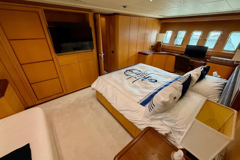 Slide: The Image of Luxurious bedroom interior of 2005 Mangusta 92 yacht with wood paneling and large windows. - 12