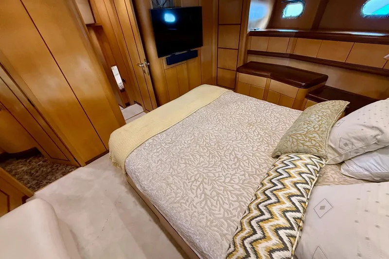 Slide: The Image of Luxurious bedroom interior of 2005 Mangusta 92 yacht with elegant wood paneling and cozy bedding. - 14