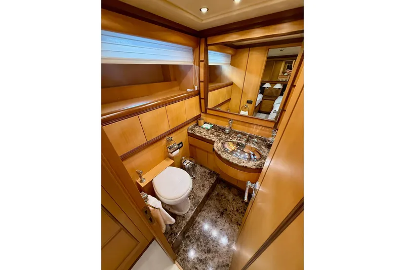 Slide: The Image of Luxurious bathroom in a 2005 Mangusta 92 yacht with marble countertop and wooden cabinetry. - 17