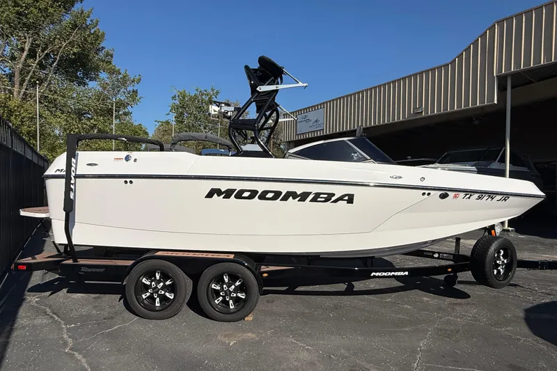 The Image of 2021 Moomba Max boat on trailer, parked outdoors near a building. - 0